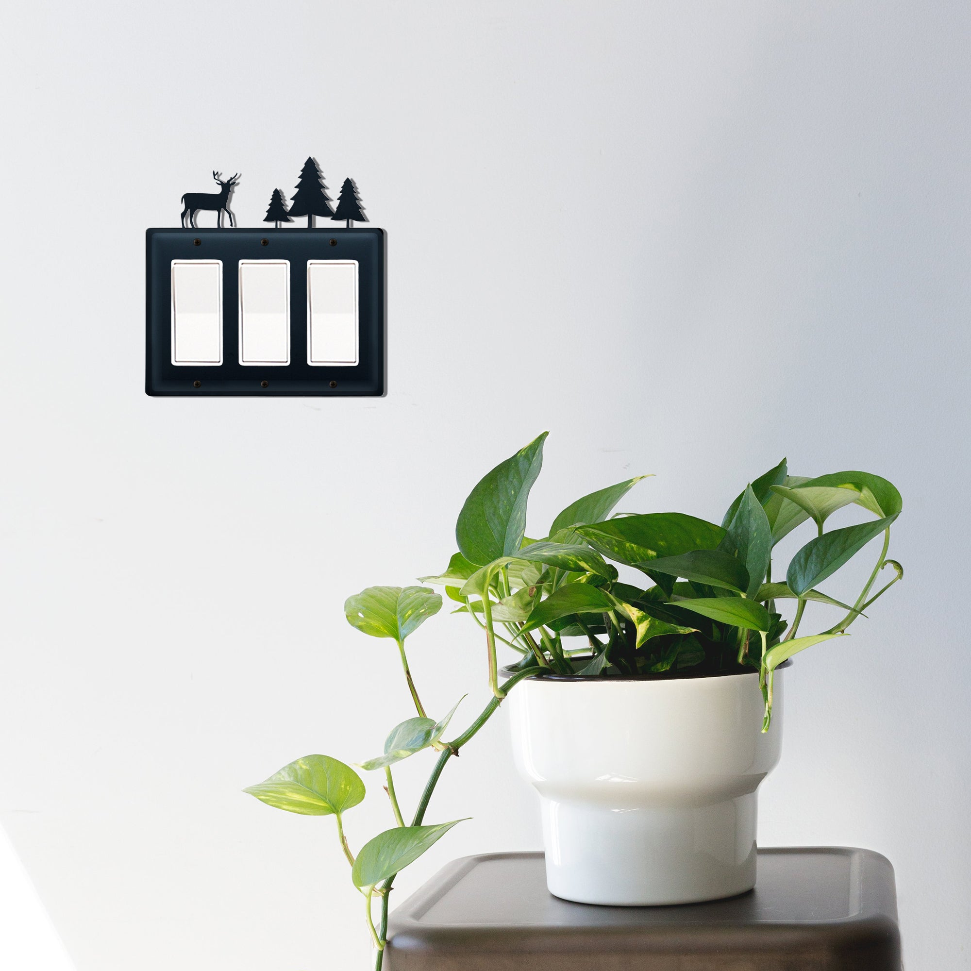 Decorative triple GFI cover with deer and tree in a room setting