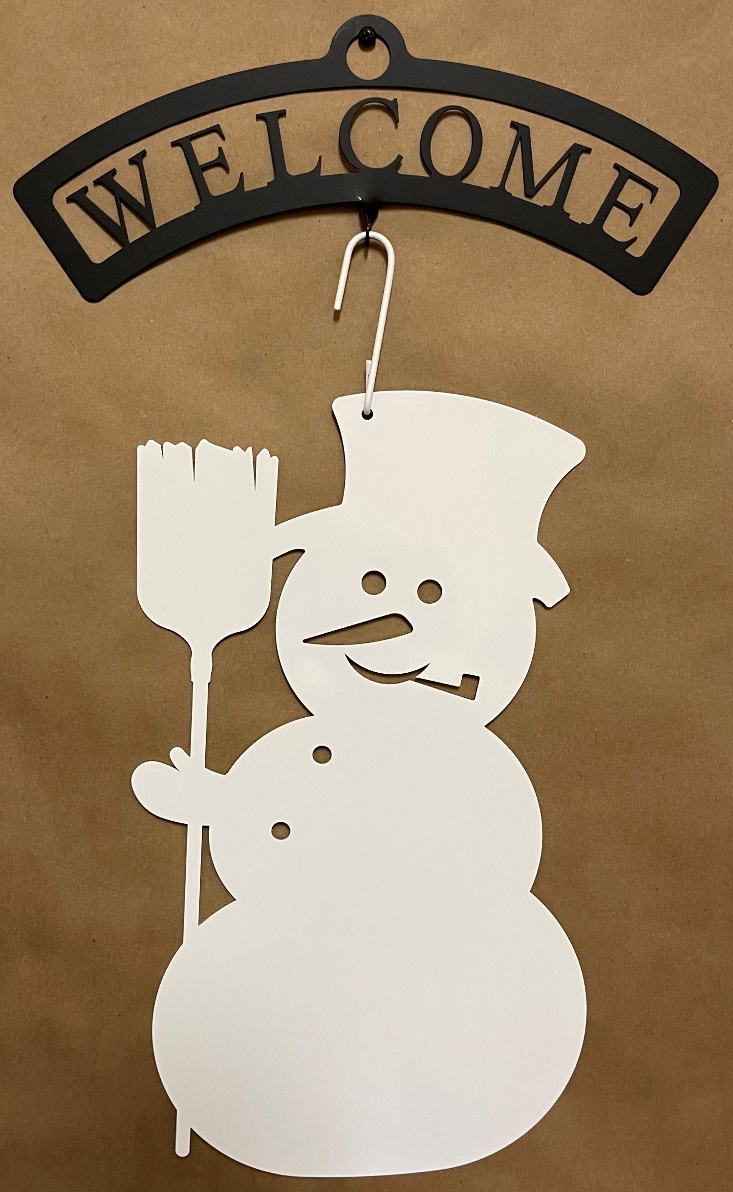 Wrought iron welcome sign with white snowman silhouette