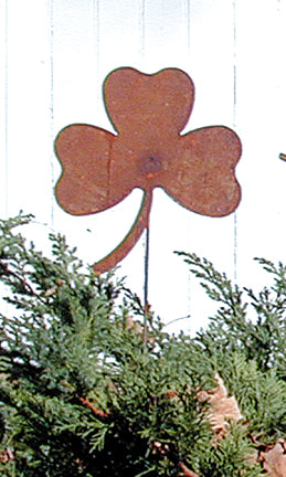 Rusted shamrock garden stake in greenery