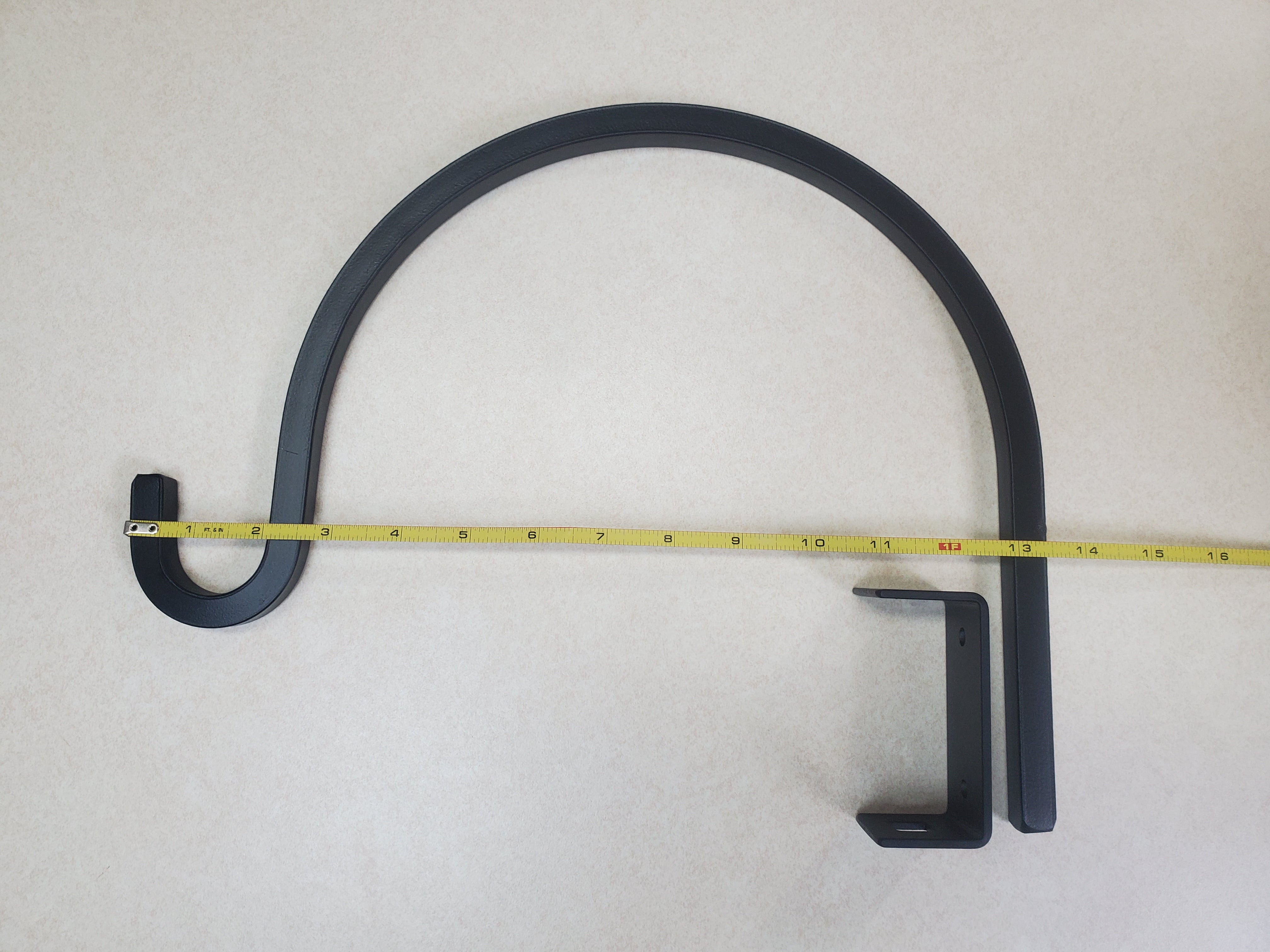 Iron plant hanger with measuring tape showing dimensions